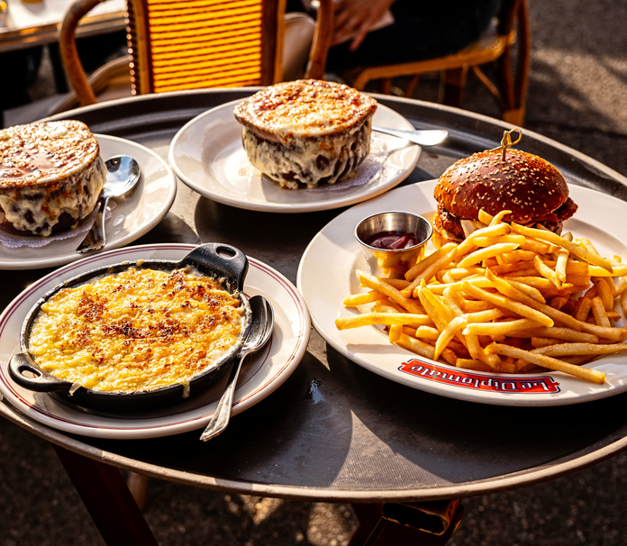 Burger, fries, and baked dishes on a restaurant tray.
