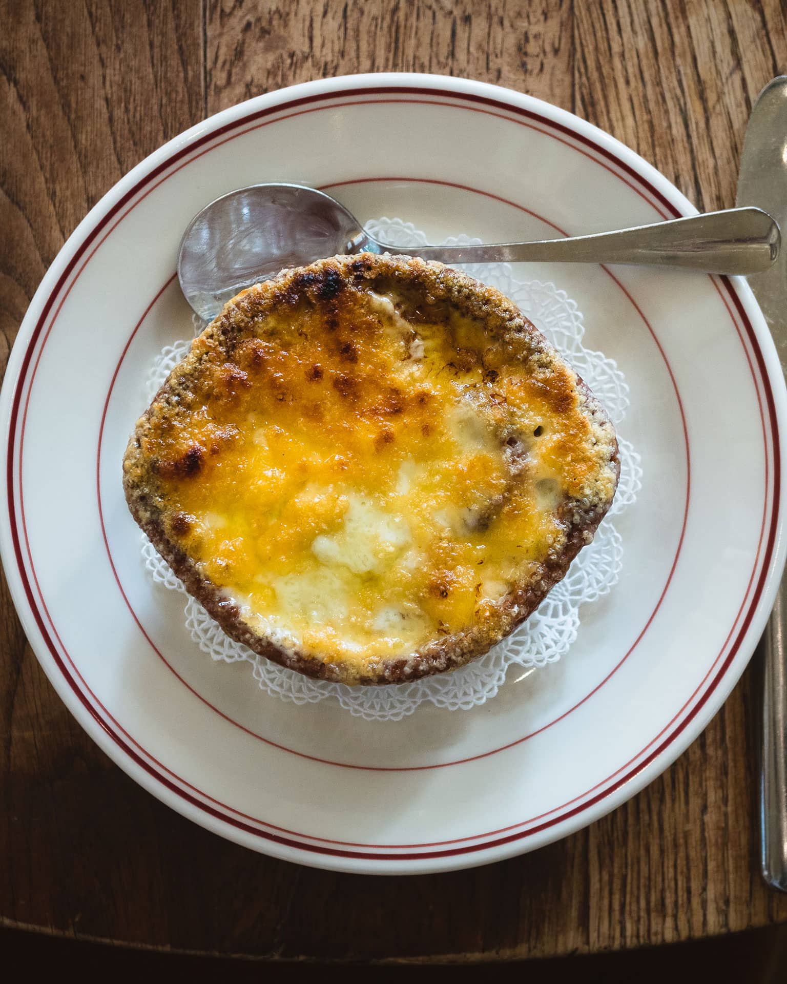 Overhead view of French onion soup on a doily